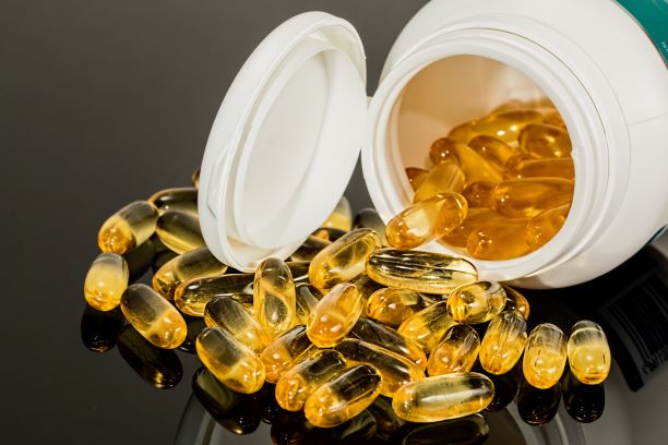 Fish Oil Supplements Bottle with capsules spilling out