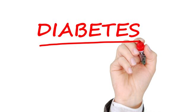 Hand writing the text diabetes in red ink