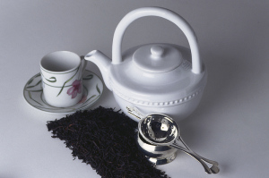 Tea Pot with tea cup, saucer and ground tea