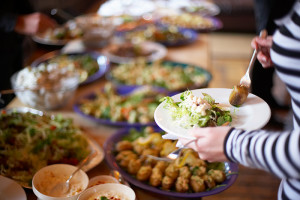 Individual loading their plate at buffet table