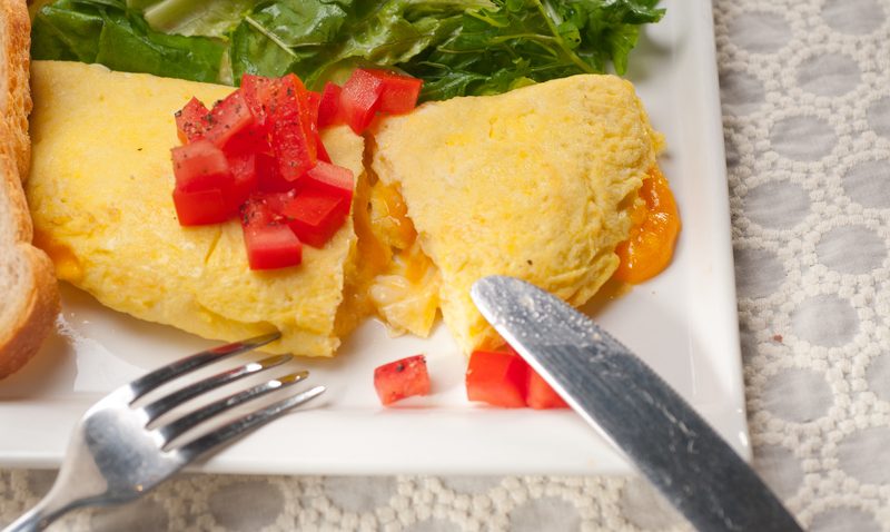 Egg omelet with tomatoes on a white plate