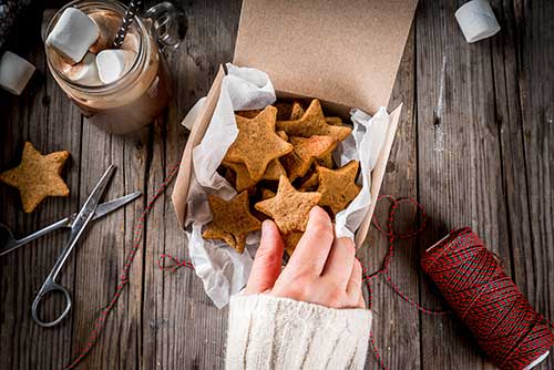 Hand preparing cookies for shipping