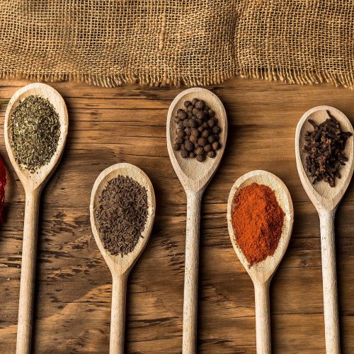various spices on wooden spoons