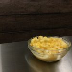 butternut squash mac in glass bowl on stainless steel table