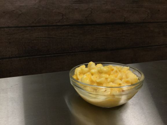 butternut squash mac in glass bowl on stainless steel table