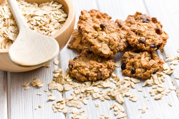 Oatmeal cookies next to a bowl of raw oats