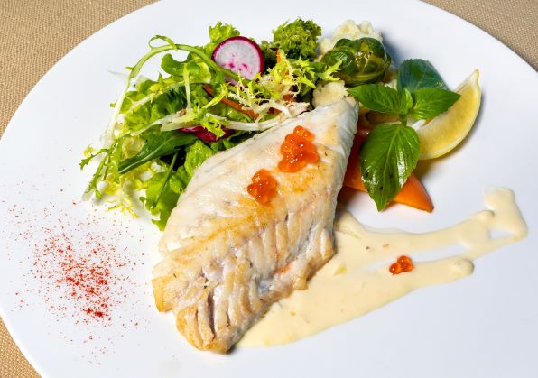 Halibut fillet on plate with salad