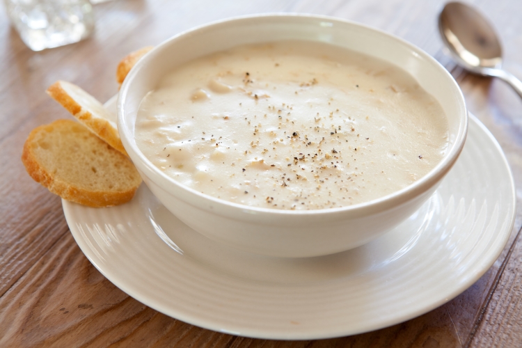clam chowder in a white bowl on a saucer