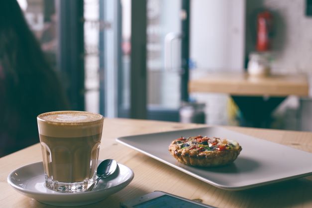 Individual frittata with class of coffee next to it on the table